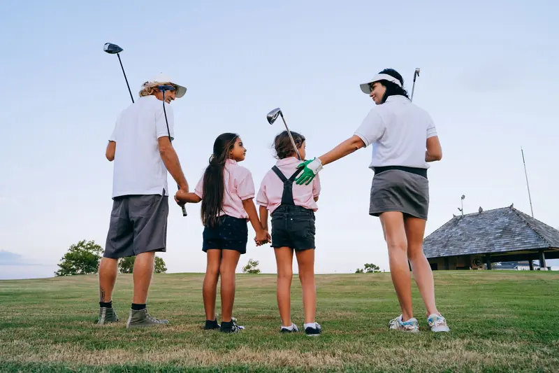 Happy family with children spending quality time playing golf together outdoors