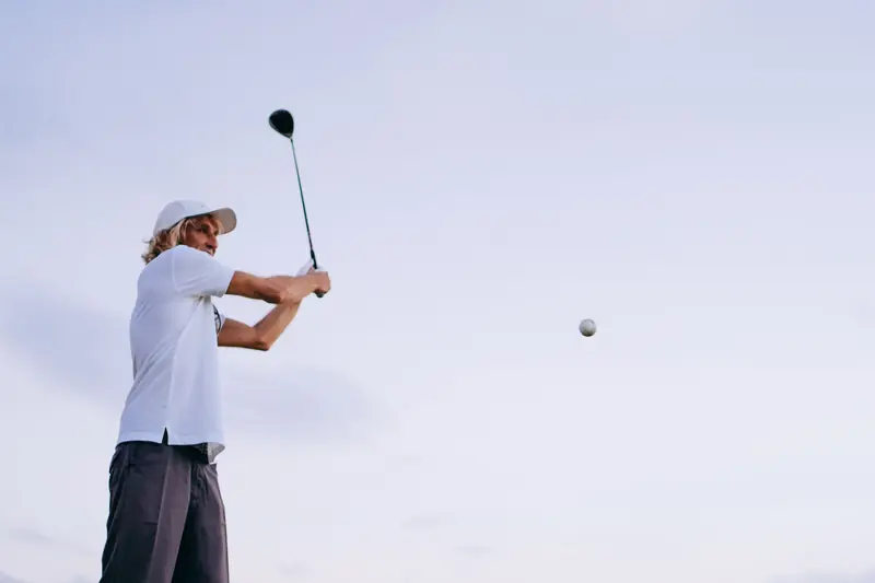 A man enjoying a golf swing on a bright day, capturing the essence of outdoor sports