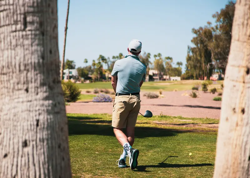 A golfer taking a tee shot on a sunny day at a Scottsdale, Arizona golf course