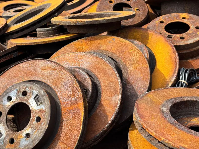 Close-up of rusty car brake discs stacked outdoors, capturing texture and patina